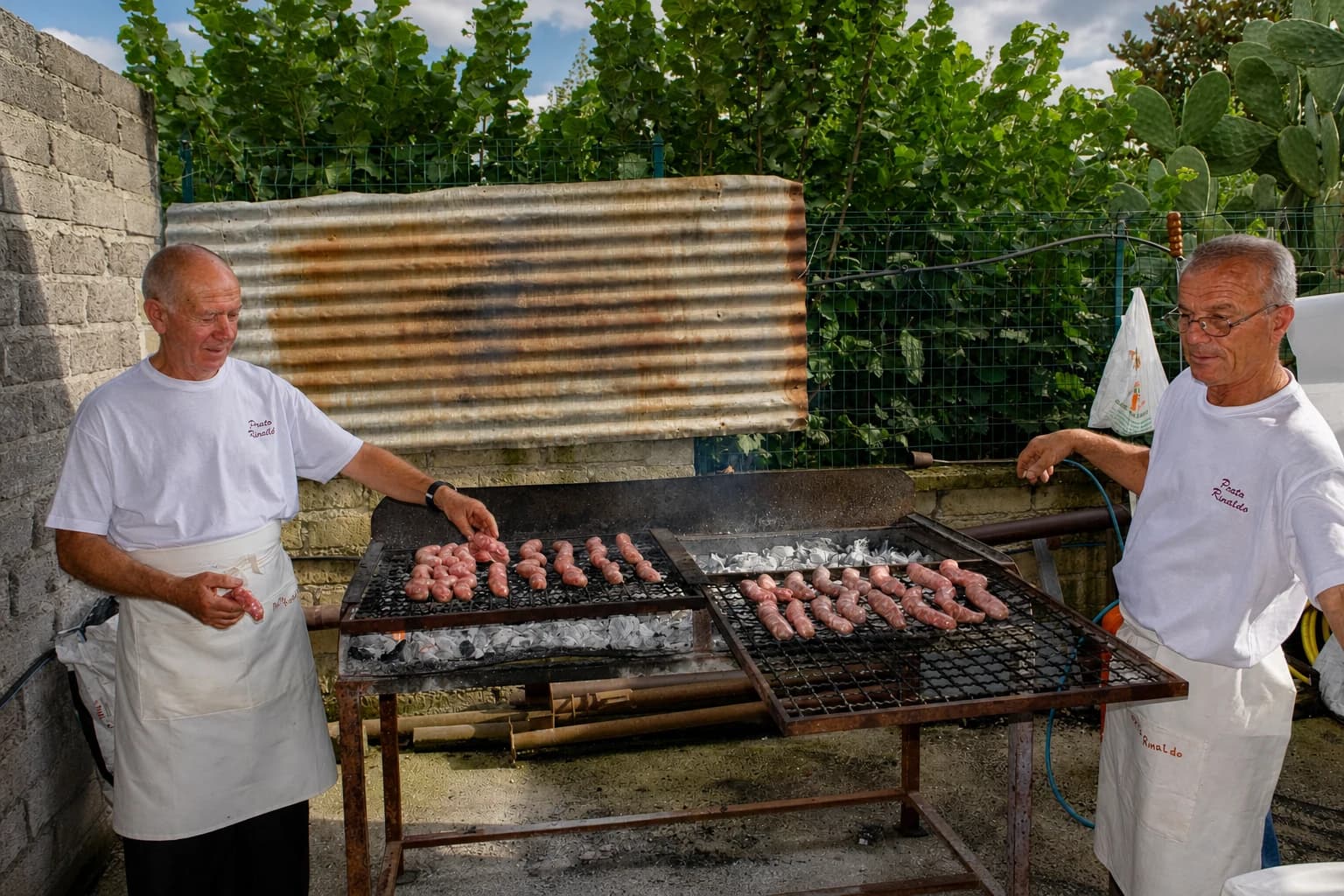 Due volontari di Prato Rinaldo cuociono le salsicce sulla grande griglia nel 2014.