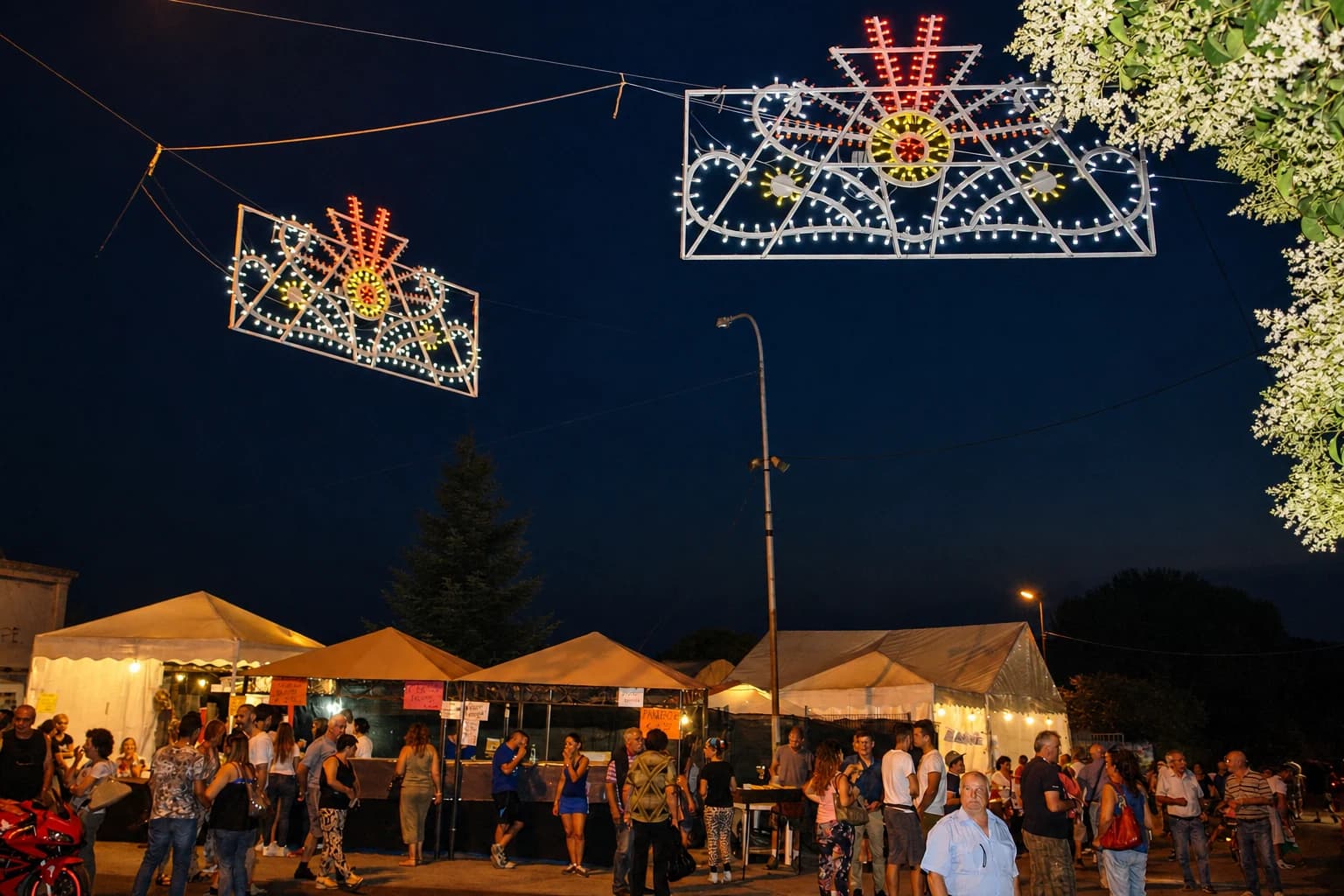 Le luminarie accese, gli stand e le persone alla Festa di Prato Rinaldo nel 2015.
