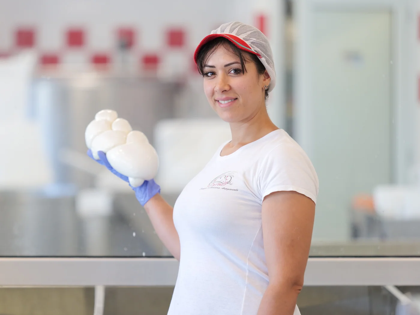 Janette nel Caseificio Artigianale Castelli presenta una treccia di mozzarella.